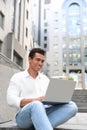 Handsome young African-American man with laptop sitting on stairs Royalty Free Stock Photo