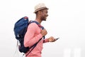 Handsome young african american man smiling with cellphone and bag against white background Royalty Free Stock Photo