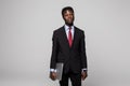 Handsome young African man in formalwear move with laptop in hands while standing against grey background Royalty Free Stock Photo