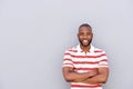 Handsome young african man smiling with arms crossed by wall Royalty Free Stock Photo