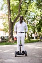 Handsome young afro american man rides on gyroscooter in the park.