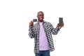 handsome young american man in plaid shirt holding smartphone and credit card. e-business concept Royalty Free Stock Photo