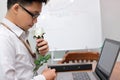 Handsome young Asian business man preparing a white rose for his girlfriend in valentines day. Love and romance in workplace conce Royalty Free Stock Photo