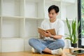 Handsome young Asian male college student reading a book in campus library Royalty Free Stock Photo