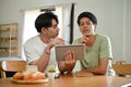 A handsome young Asian male gay couple is studying an online lesson at home together Royalty Free Stock Photo