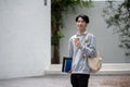 A handsome young Asian male student is walking down his campus building Royalty Free Stock Photo