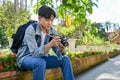 Handsome Asian male traveler preparing his camera before shooting, traveling at beautiful temple Royalty Free Stock Photo