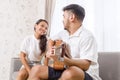 Handsome young asian man playing acoustic guitar and singing for his beautiful girlfriend Royalty Free Stock Photo