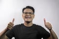 handsome young asian man showing thumbs up with both hands and smiling on white background Royalty Free Stock Photo