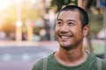 Handsome young Asian man standing on a city street smiling Royalty Free Stock Photo