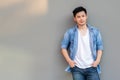 Handsome young Asian man wear denim shirt, looking at camera. Portrait young Asia cool guy with hands in pockets leaning against Royalty Free Stock Photo