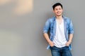 Handsome young Asian man wear denim shirt, looking at camera. Portrait young Asia cool guy with hands in pockets leaning against Royalty Free Stock Photo