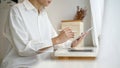 A handsome young Asian man in white shirt using his digital tablet in a coffee shop Royalty Free Stock Photo