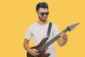 Handsome young asian men playing guitar and  listen music with headphones  isolated on yellow background Royalty Free Stock Photo