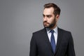 Handsome young bearded business man in classic black suit shirt tie posing isolated on grey background studio portrait Royalty Free Stock Photo