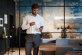 Handsome young bearded business man in office using mobile phone indoors. Royalty Free Stock Photo