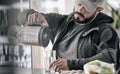 Handsome young bearded caucasian male fill glass with fruit orange juice beverage in fitness club bar after heavy workout weight