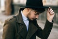 Handsome young bearded hipster man guy in hat Fedora on street with suitcase. Retro vintage fashion look Royalty Free Stock Photo
