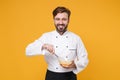 Handsome young bearded male chef cook or baker man in white uniform shirt posing isolated on yellow background studio Royalty Free Stock Photo