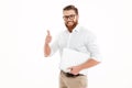 Handsome young bearded man holding laptop showing thumbs up. Royalty Free Stock Photo