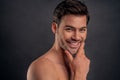 Handsome young bearded man isolated. Portrait of shirtless muscular man is standing on grey background and looking at camera. Royalty Free Stock Photo