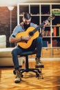 Young bearded man playing classical guitar at home Royalty Free Stock Photo