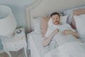 Handsome young bearded man sleeping in spacious comfortable bed