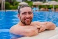 Happy smiling bearded man in the swimming pool on sunny day Royalty Free Stock Photo