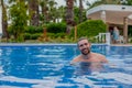 Happy smiling bearded man in the swimming pool on sunny day Royalty Free Stock Photo