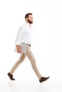 Handsome young bearded man walking over white wall Royalty Free Stock Photo