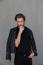 Handsome young bearded man wearing biker leather jacket. Vertical.