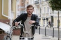 Handsome young bike messenger with backpack and bicycle looks at camera