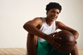 Handsome young black basketball player sitting on the wooden floor Royalty Free Stock Photo