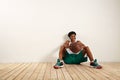 Handsome young black basketball player sitting on the wooden floor Royalty Free Stock Photo