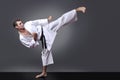 Handsome young black belt male karate doing kick