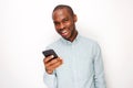 Handsome young black man holding mobile phone against white background