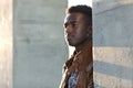 Handsome young black man stands between concrete pillars