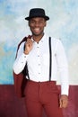 Handsome young black man in vintage suit and hat smiling by wall Royalty Free Stock Photo