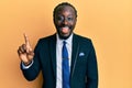 Handsome young black man wearing business suit and tie smiling with an idea or question pointing finger up with happy face, number Royalty Free Stock Photo