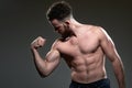 Handsome young body builder, on grey background Royalty Free Stock Photo