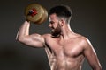 Handsome young body builder using bar bell, on grey background Royalty Free Stock Photo