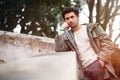 Handsome young bored man leaning on a wall. Outdoor