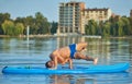 Boy doing handstanding position on paddle board during hot summer day. Royalty Free Stock Photo