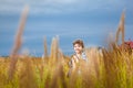 Handsome young boy having fun playing on the meadow in summer wi