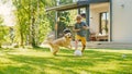 Handsome Young Boy Plays Soccer with Happy Golden Retriever Dog at the Backyard Lawn. He Plays Foo Royalty Free Stock Photo