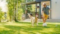 Handsome Young Boy Plays Soccer with Happy Golden Retriever Dog at the Backyard Lawn. He Plays Foo Royalty Free Stock Photo