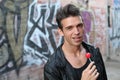 Handsome young brunette man with a lollipop, isolated against urban graffiti background Royalty Free Stock Photo