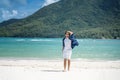 A handsome young brunette man walks on a paradise tropical beach with white sand and azure water, travel and vacation on the Royalty Free Stock Photo