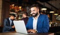 Handsome young business man, blogger or remote working with laptop in bar Royalty Free Stock Photo