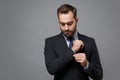 Handsome young business man in classic black suit shirt tie posing isolated on grey background studio portrait Royalty Free Stock Photo